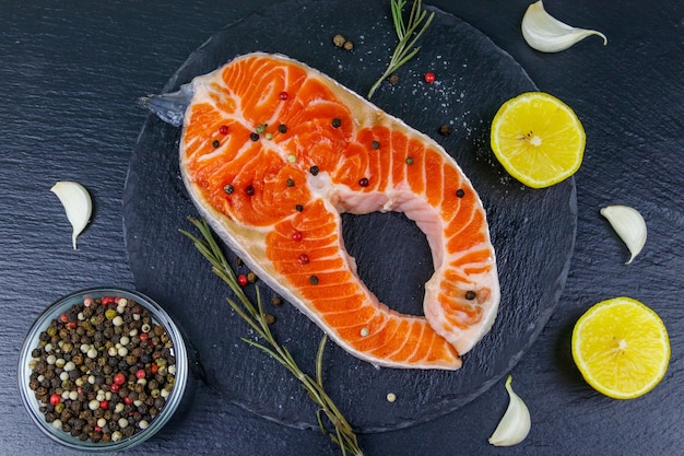 Filete de salmón crudo con especias en pizarra negra Vista superior