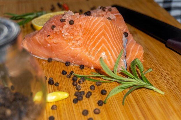 Filete de salmón crudo fresco sobre tabla de cortar de madera