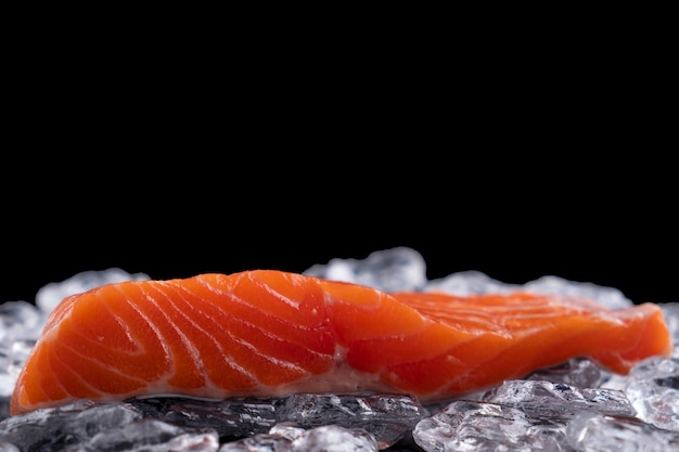 Filete de salmón crudo en hielo sobre una superficie oscura