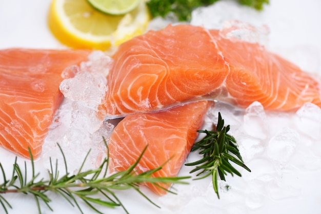 Filete de salmón crudo con hierbas y especias sobre fondo negro oscuro, pescado de salmón fresco en hielo