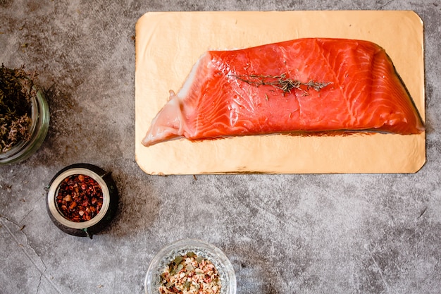 Filete de salmón crudo en tablero de oro sobre pizarra gris