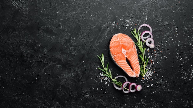 Filete de salmón e ingredientes sobre fondo de piedra negra Vista superior Espacio libre para el texto