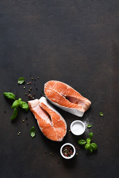 Filete de salmón con especias sobre una mesa de cocina de hormigón. Vista superior con espacio de copia.