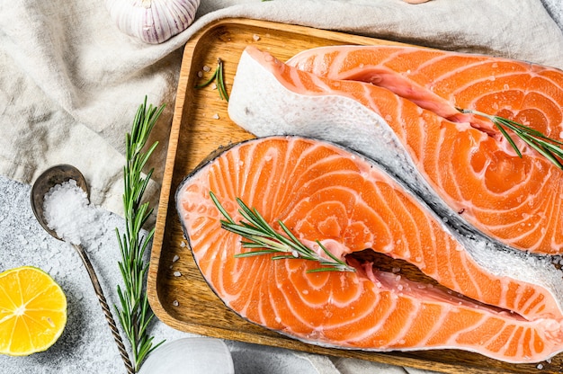 Filete de salmón fresco en bandeja de madera con especias. Pez atlántico. Fondo gris Vista superior