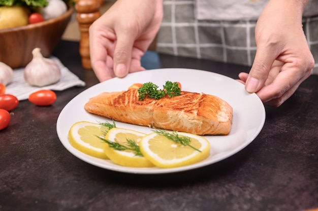 Filete de salmón fresco con ensalada. Aprendizaje en línea para cocinar una dieta y alimentos saludables cuando se queda en casa durante el coronavirus.