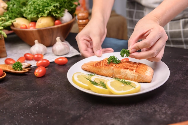 Foto filete de salmón fresco con ensalada. aprendizaje en línea para cocinar dietas y alimentos saludables cuando se queda en casa durante el coronavirus.