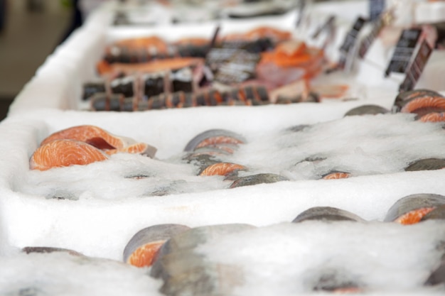 Foto filete de salmón en el hielo en el mostrador de la tienda.