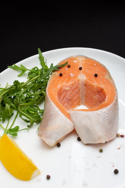 Filete de salmón con ingredientes para cocinar en un plato