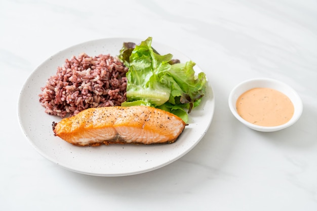 filete de salmón a la parrilla con bayas de arroz y vegetales - estilo de comida saludable