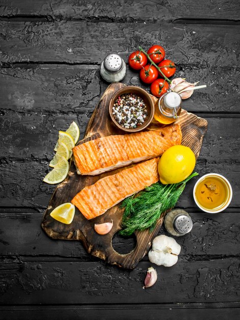 Foto filete de salmón a la parrilla con especias hierbas y ramas de eneldo fresco