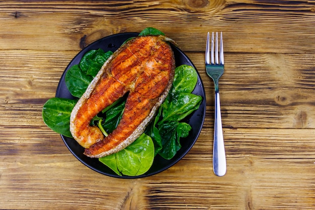 Filete de salmón a la parrilla con espinacas en la mesa de madera Vista superior