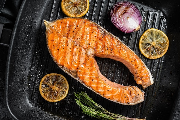 Filete de salmón a la parrilla en una sartén con hierbas Fondo negro Vista superior