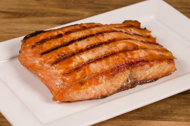Filete de salmón a la parrilla servido en un plato blanco