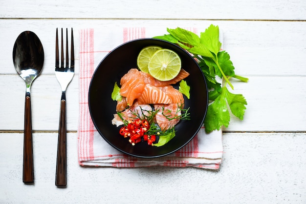 Filete de salmón pescado en bolw y cuchara tenedor sobre fondo de mesa de comedor