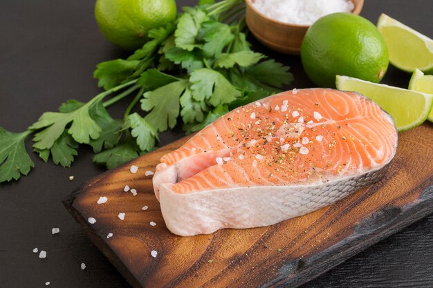 Filete de salmón pescado crudo preparado para cocinar. Vista superior de la mesa negra.