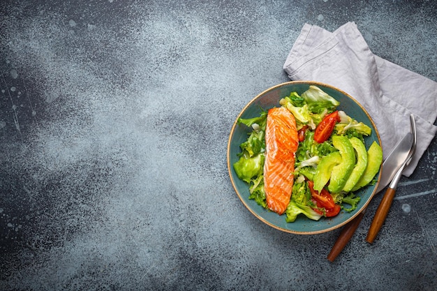 Filete de salmón de pescado a la parrilla y ensalada de verduras con aguacate