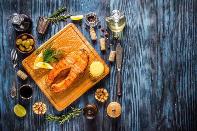 Filete de salmón a la plancha con limón sobre fondo de madera rústico