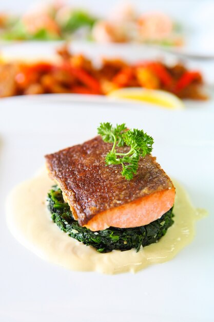 Filete de salmón a la plancha en un plato blanco, enfoque selectivo