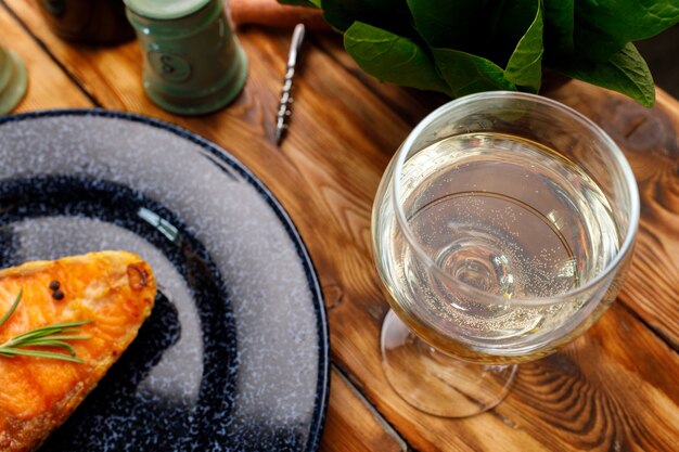 Filete de salmón a la plancha sobre placa azul sobre mesa de madera