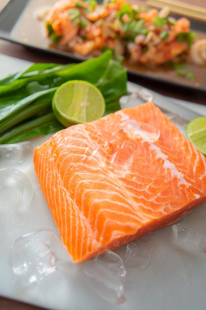 Filete de salmón El salmón crudo fresco se coloca en hielo con una rodaja de limón al lado