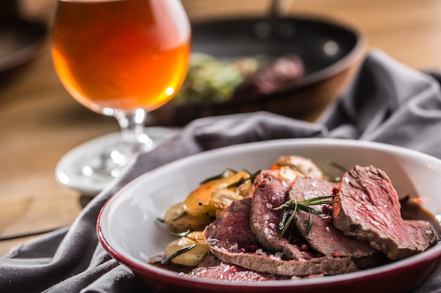 Filete de solomillo de ternera en rodajas, patatas al romero y cerveza de barril.