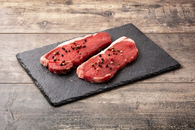 Filete de ternera aderezado con pimienta sobre mesa de madera