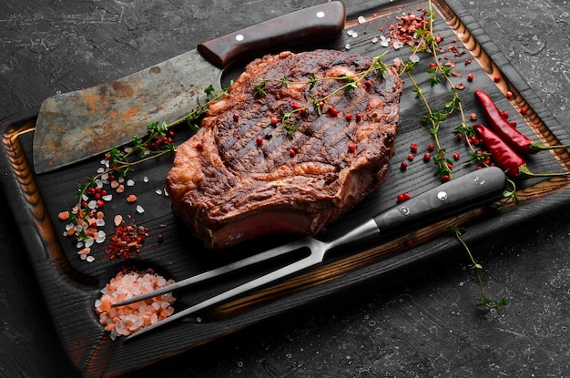 Filete de ternera chuletón a la parrilla envejecido en seco con ingredientes sobre un fondo de piedra negra Vista superior espacio de copia libre