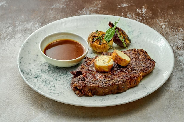 Filete de ternera clásico con mantequilla picante y salsa en un plato. primer plano, enfoque selectivo