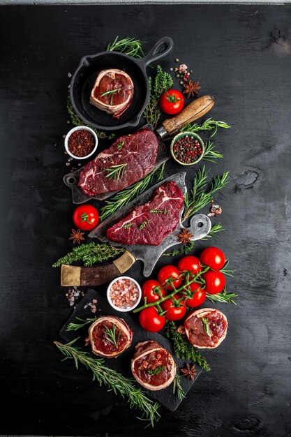 Filete de ternera cruda bistec Mignon con pimienta y sal filete mignon filetes de lomo de ternera envueltos en tocino y tomillo en la vista superior de fondo oscuro