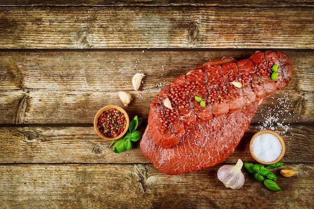 Filete de ternera cruda con especias en una mesa de madera