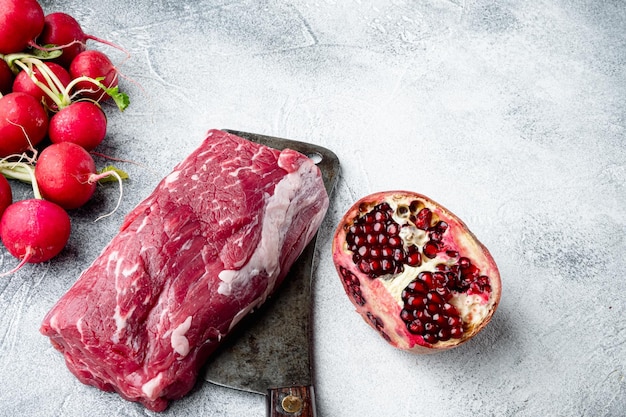 Filete de ternera cruda fresca Mignon con sal pimienta tomillo ajo Listo para cocinar en un viejo cuchillo de carnicero sobre fondo de piedra gris con espacio para copiar texto