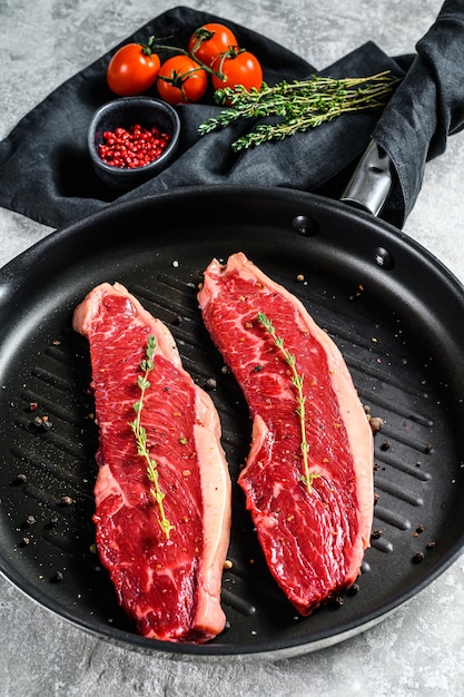 Filete de ternera cruda de mármol en una sartén parrilla, ingredientes para cocinar