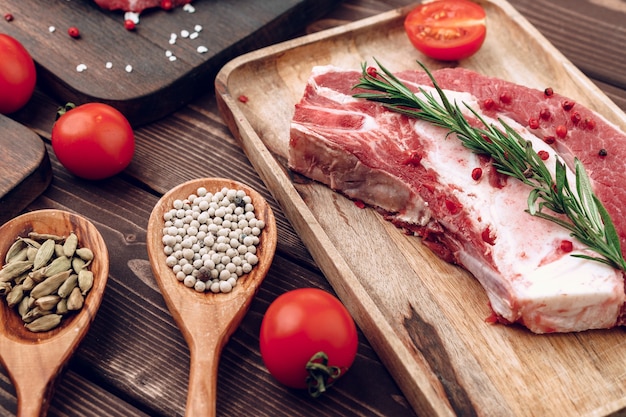 Filete de ternera cruda con romero y especias sobre tabla de madera