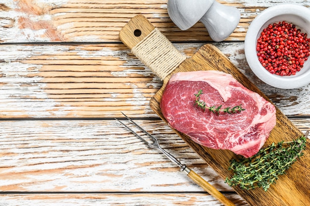 Filete de ternera cruda sobre una tabla de cortar con espacio de copia