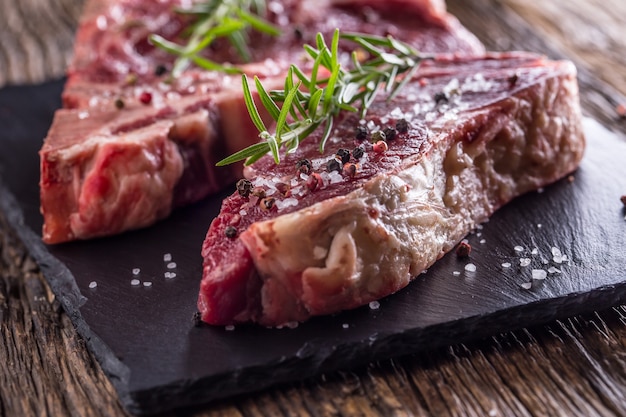 Filete de ternera crudo. Chuletón fresco crudo con sal pimienta y romero.