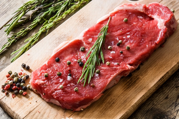 Filete de ternera crudo con picante listo para ser cocinado en mesa de madera