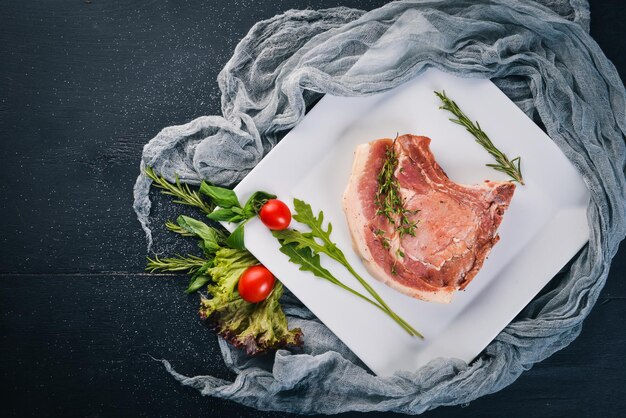 Filete de ternera crudo en un plato Sobre un fondo de madera Vista superior Espacio libre para texto