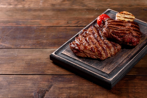 Filete de ternera delicioso jugoso fresco en una mesa oscura. Plato de carne con especias y hierbas.