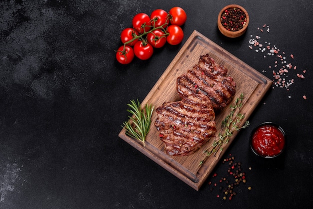 Filete de ternera delicioso jugoso fresco sobre un fondo oscuro. Plato de carne con especias y hierbas.