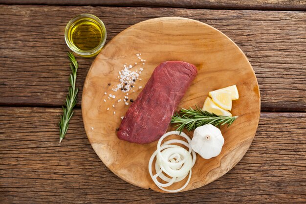 Filete de ternera e ingredientes sobre tabla de madera