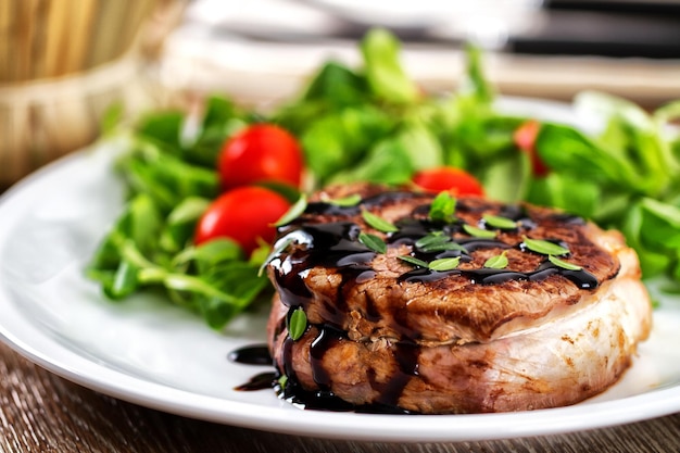 Foto filete de ternera con ensalada verde y tomates cherry