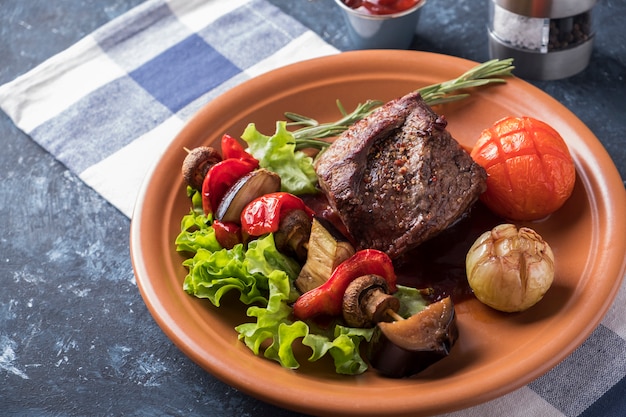 Filete de ternera especias sirve verduras asadas en un plato.