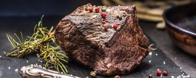 Filete de ternera jugoso con especias y hierbas en la tabla de cortar.