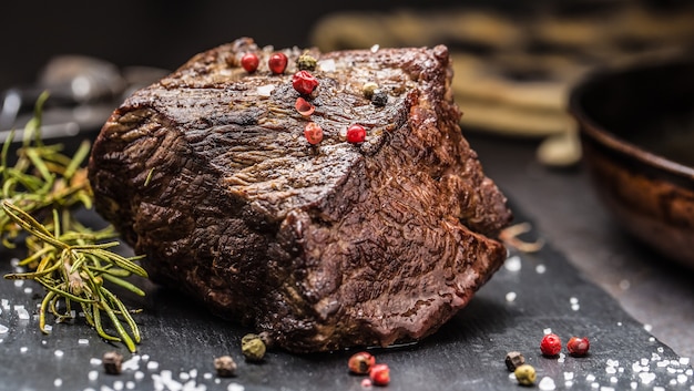 Filete de ternera jugoso con especias y hierbas en la tabla de cortar.