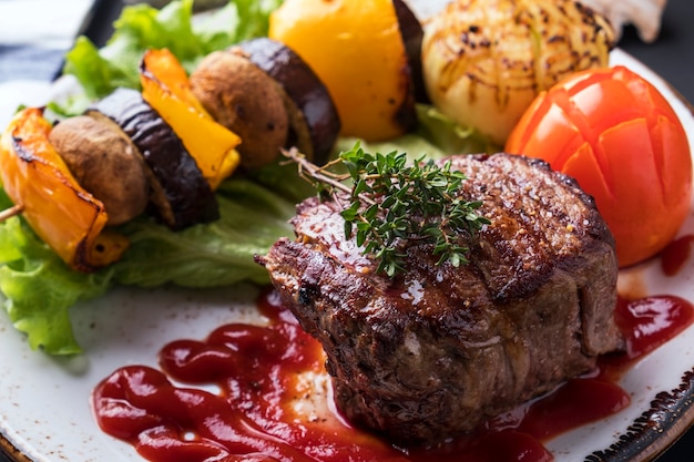 Filete de ternera mediano jugoso con salsa roja y verduras asadas