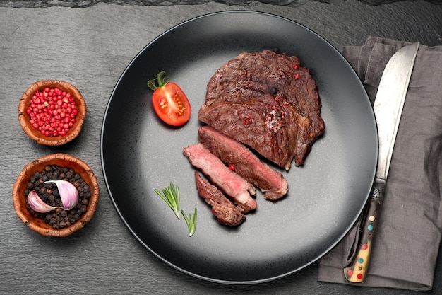 Filete de ternera medio chuletón sobre fondo de piedra negra