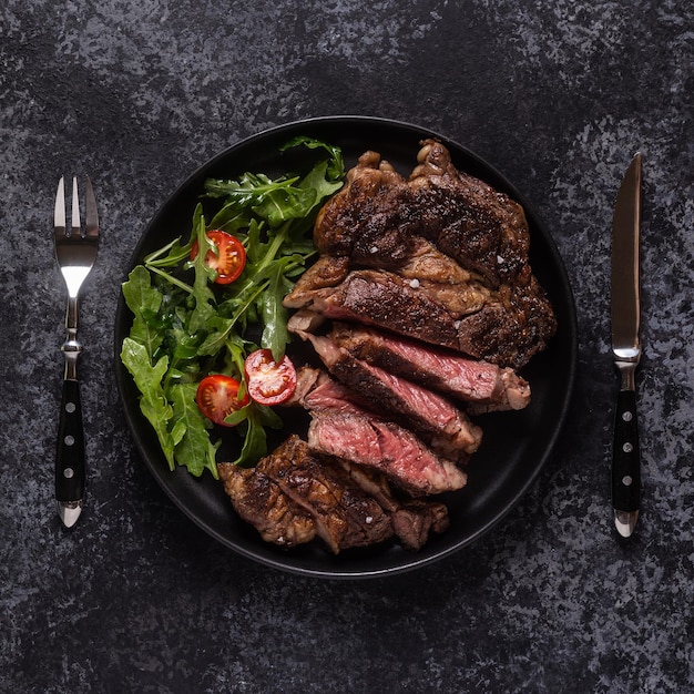 Filete de ternera a la parrilla con especias en una vista superior de placa negra