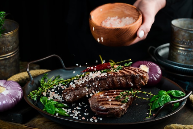 Filete de ternera a la parrilla con hierbas y especias en una mesa oscura Vista superior Espacio libre para el texto