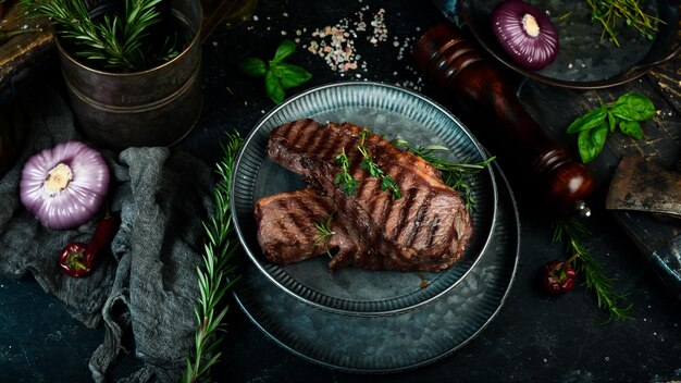 Filete de ternera a la parrilla con hierbas y especias en una mesa oscura Vista superior Espacio libre para el texto