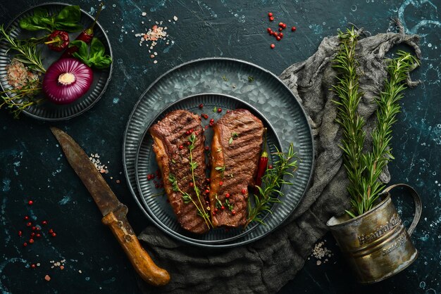 Filete de ternera a la parrilla con hierbas de romero y especias en una mesa oscura Espacio libre para menús